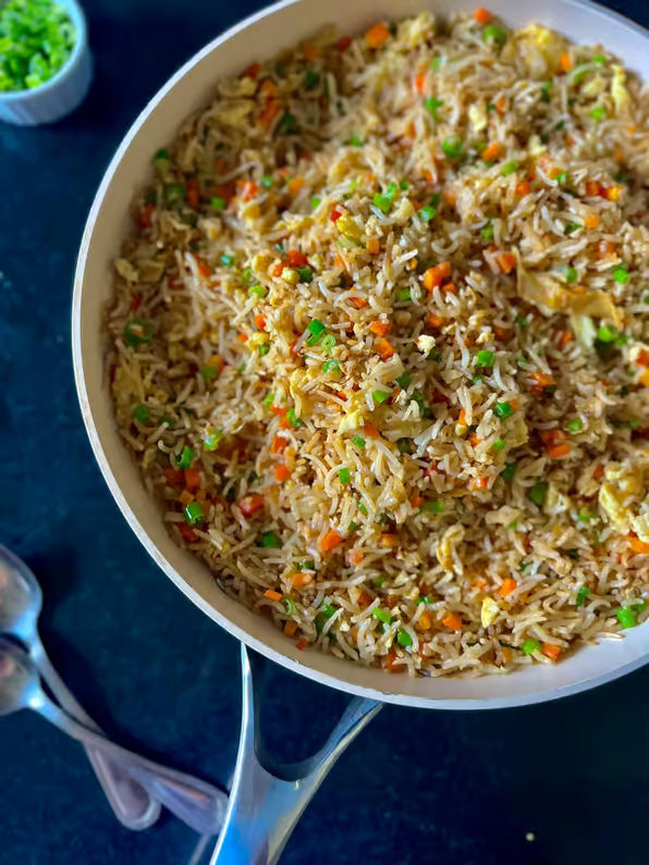 Närbild på stekpanna med stekt ris, morötter, gröna ärtor och ägg - perfekt mål innan fiskeresa för sportfiskare.