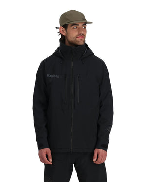 Man i svart Simms Pro Dry GORE-TEX-fiskejacka och khakikeps, redo för fiskeresa, mot enkel vit bakgrund.